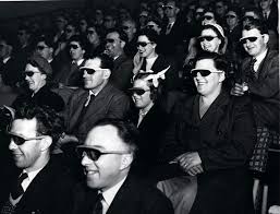 Photograph of people wearing 3-D glasses at the movies.